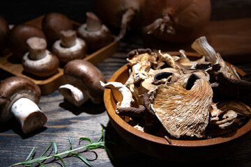 dried mushrooms in a wooden bowl on a dark table. Close-up.