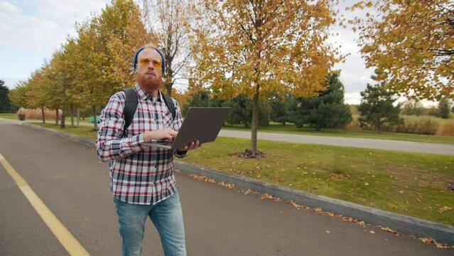 Thoughtful young man in bini hat with backpack looking around, strolling on territory with beautiful landscape, thinking of problem, finding solution. High quality 4k footage