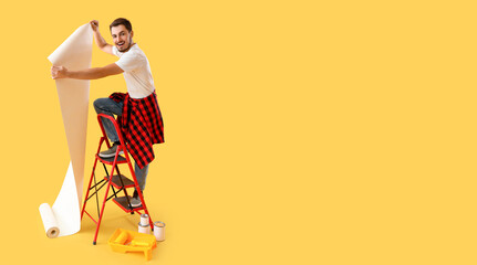 Young man with ladder and wallpapers on yellow background with space for text - obrazy, fototapety, plakaty