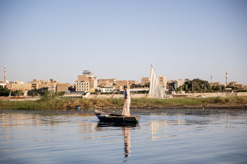 fisherman on a small boat in the nile river luxor egypt