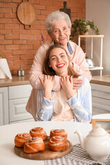 Fototapeta na wymiar Senior woman hugging her grandmother in kitchen