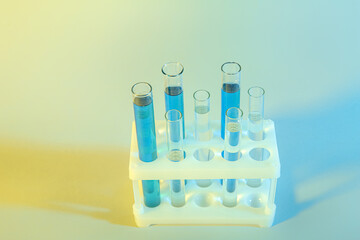 Test tubes with different samples in stand on colorful background