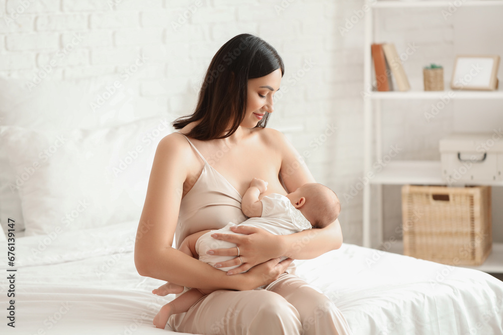 Poster young woman breastfeeding her baby in bedroom