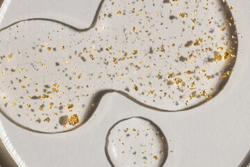 drop of serum with gold on white background, cosmetic textures, skincare product smudge face serum, oil	