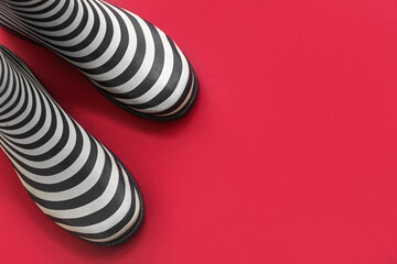 Stylish gumboots on red background