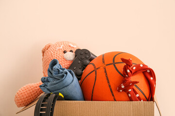 Box of unwanted stuff for yard sale on beige background