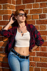 Captivating Portrait of a Redhead Woman Posing Against Red Brick Wall - 676145517