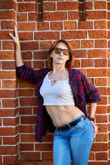 Captivating Portrait of a Redhead Woman Posing Against Red Brick Wall - 676145534