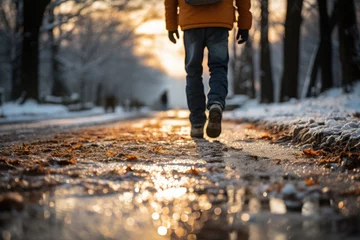 Foto auf Acrylglas The first autumn rains leave puddles of water on a path while a pedestrian walks calmly © Rafa