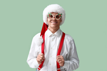 Santa Claus in Christmas glasses on green background