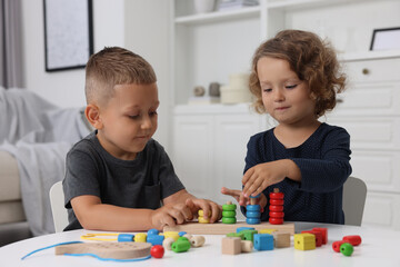 Fototapeta premium Motor skills development. Little kids playing with stacking and counting game at table indoors
