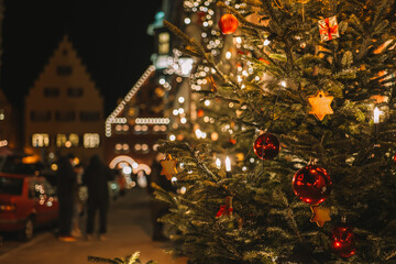 Obraz na płótnie Canvas Christmas tree with balls and shining garlands.Rothenburg ob der Tauber Christmas evening square with people walking. Soft focus. Streets of the evening Christmas city.