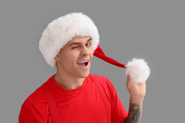 Young Santa Claus on grey background