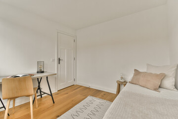 a bedroom with a bed, desk and mirror on the wall in front of the window looking out to the outside