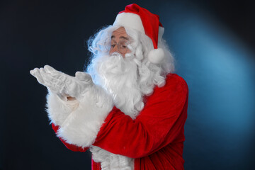 Man in Santa Claus costume on color background