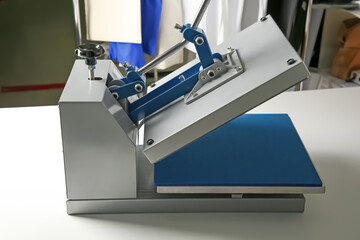 Printing logo. Modern heat press machine on white table