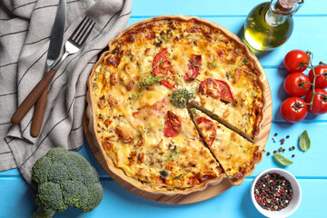 Tasty quiche with tomatoes, microgreens and cheese served on light blue wooden table, flat lay