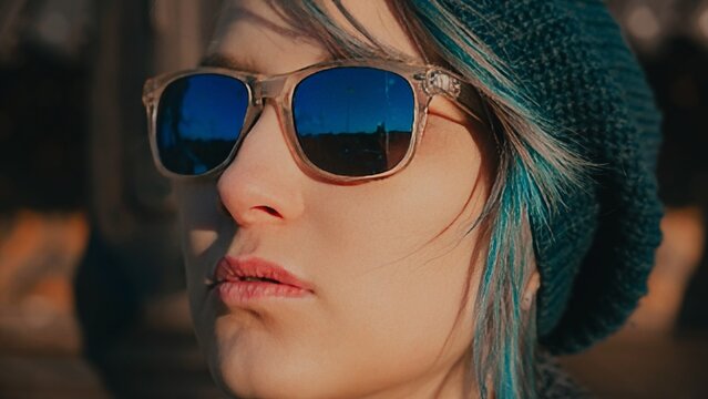 Caucasian girl with long colored hair wearing sunglasses close-up