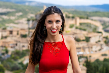Mujer con vestido rojo, posa para retrato en un bonito pueblo de España. 50 mm