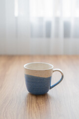 Vertical blue and white vintage cup on wood table