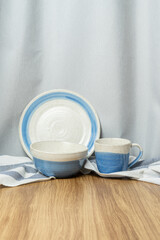 Vertical set of blue and white tableware on wood table and gray background