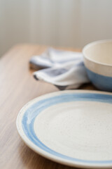 Close of blue and white dish with tableware on wood table