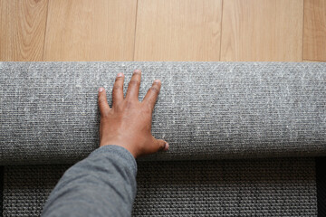top view of men rolling out new rug.