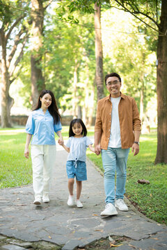 Photo of young Asian family at park