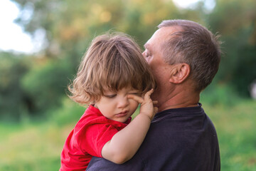 Fototapeta premium Grandson and grandfather playing on the river bank