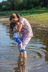 Grandson and grandmother playing on the river bank