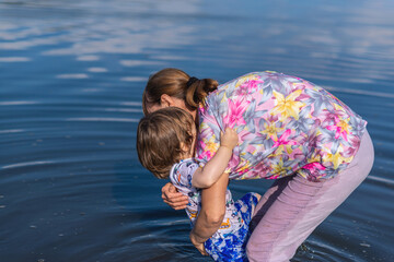 Grandson and grandmother playing on the river bank
