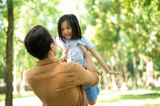Photo of Asian father and daughter at park