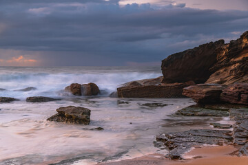 Fototapeta na wymiar Sunrise seascape with low clouds and waves