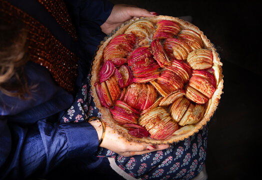 A woman holding an apple pie 