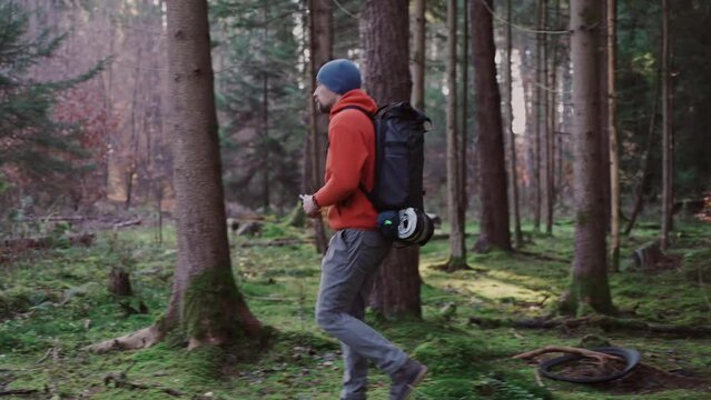 Hiker using mobile application to navigate in fall forest. Pathfinder tries to find best way in woods. Active lifestyle, touring concept. Backpacking trip. Following route. Lost in the wilderness. 