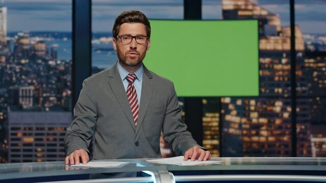 Evening news journalist broadcasting at greenscreen monitor tv studio closeup