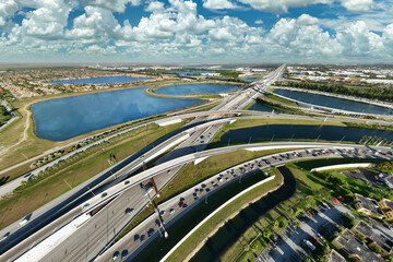 Fototapeta premium Aerial view of american highway junction with fast driving vehicles in Miami, Florida. View from above of USA transportation infrastructure