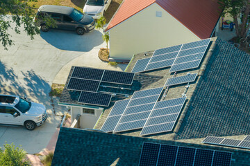 Residential house in USA with rooftop covered with solar photovoltaic panels for producing of clean...