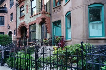 Row of ornate old 19th century townhouses with small front garden