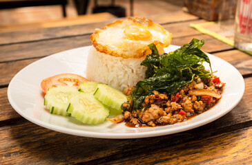 Stir-fried pork and basil leaves with rice and a fried egg. Popular Thai  street food.