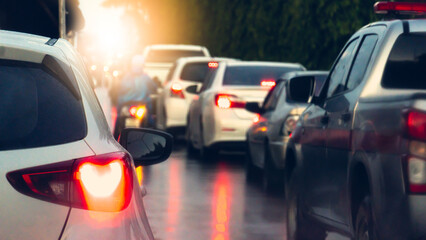Abstract of white car taillights illuminate with bright of brake lights. Casting a glow through the mist of scattered rain. Traffic is congested during the rainy period. with cars queued in line. - obrazy, fototapety, plakaty
