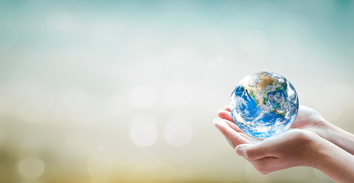 Earth day concept, Human hand holding globe on blurred green and blue nature background. Elements of this image furnished by NASA