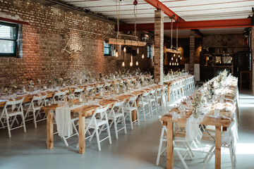 Wedding decoration with flowers and wooden tables and chairs in pastel colors 