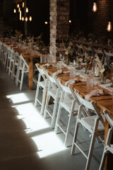 Wedding decoration with flowers and wooden tables and chairs in pastel colors 
