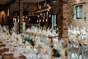 Wedding decoration with flowers and wooden tables and chairs in pastel colors 