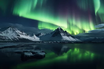Foto op Canvas Northern lights over snowy mountain range with reflection in water © Rudsaphon