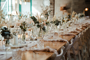 Wedding decoration with flowers and wooden tables and chairs in pastel colors 
