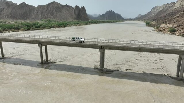 Aerial View Of Truck Driving On Hingol River Bridge. Circle Dolly Shot