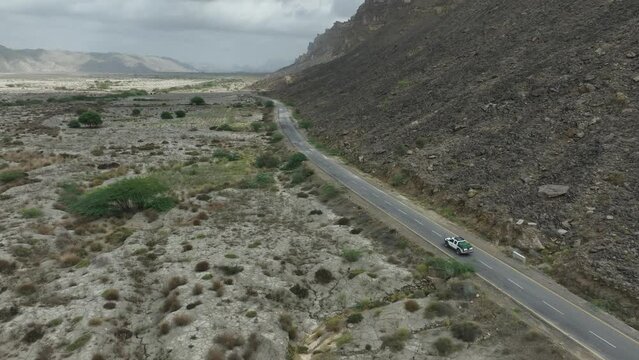 Drone following a car on the road between the rocky mountain and valley in Hingol Baluchistan Pakistan