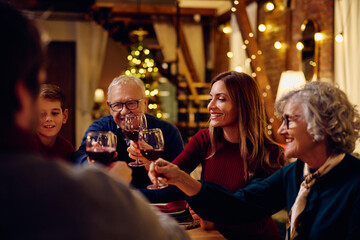 Happy extended family toasting during meal at dining table on Christmas.